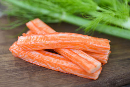 Crab sticks on wooden cutting board and vegetable , Fresh crab sticks surimi ready to eat japanese foodの写真素材