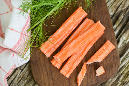Crab sticks on wooden cutting board and vegetable , Fresh crab sticks surimi ready to eat japanese foodの写真素材