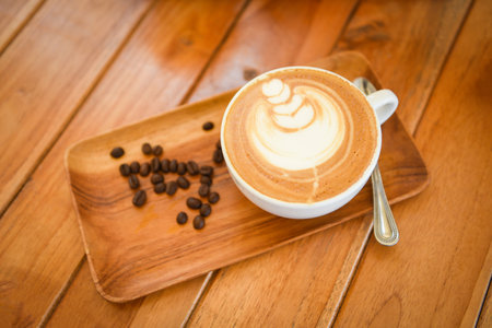 Coffee cup on wooden table in cafe with coffee beans background, Cappuccino or latte coffeeの写真素材