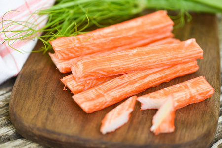 Crab sticks on wooden cutting board and vegetable , Fresh crab sticks surimi ready to eat japanese foodの写真素材