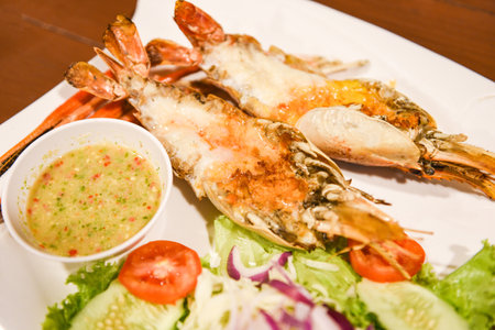 Grilled shrimp cut half with fresh vegetable and seafood sauce, Giant river prawn shrimp grilled serve on white plateの写真素材