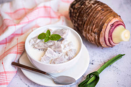 Taro food with dessert taro boiled with sugar and coconut milk on bowl and fresh raw organic taro root ready to cook, Asian Thai foodの写真素材