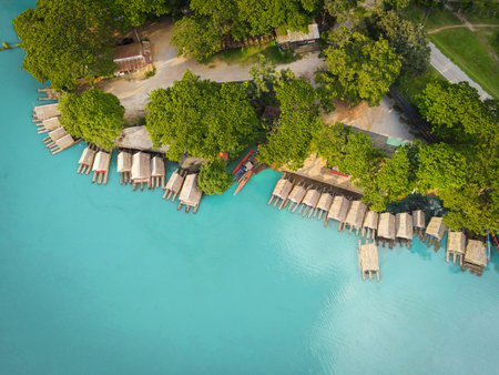 Aerial view blue water river, Top view sea blue lagoon pond water from above, Bird eye view green tree and bamboo raft house and wooden boat on water surface beautiful fresh environment landscape lakeのeditorial素材