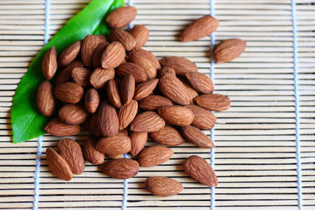 Almonds nuts on wooden with leaf almonds top view background, Roasted almond for snackの写真素材