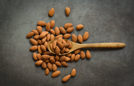 Almonds on dark background top view on the table, Close up roasted almond nuts natural protein food and for snackの写真素材