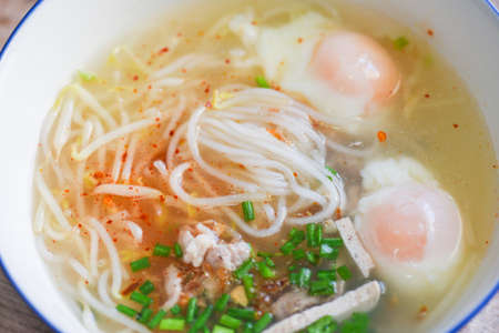 Soup bowl, soup noodle pork white noodle with vietnamese pork soft boiled eggs and bean sprout vegetable spring onion in soup bowl on wooden table, Thai Asian foodの写真素材