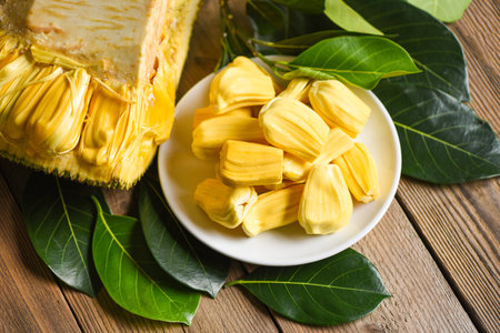 jackfruit on white plate with leaf on wooden background, ripe jackfruit peeled tropical fruit fresh...