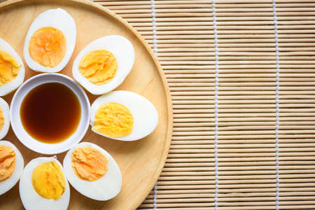 Eggs menu food boiled eggs in a wooden plate with fish sauce, cut in half egg yolks for cooking healthy eating eggs breakfast , top viewの写真素材