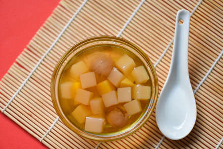 Chinese desserts, Mix ginkgo nuts cassava syrup coconut jelly in longan juice on glass bowl, Thai and Chinese longan date soup Asian dessert sweetsの写真素材