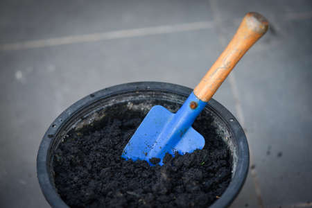 shovel on cultivation soil in black pot for planting, Preparation of soil for planting plants or flowers in potsの写真素材
