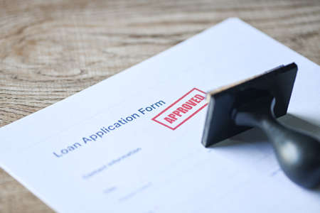 Loan approved on loan application form paper with rubber stamp on table, Loan approval business finance economy conceptの写真素材