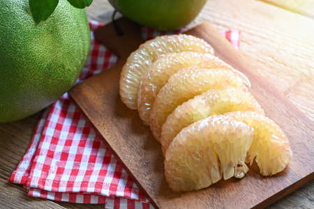 pomelo fruit on wooden background, fresh green pomelo peeled and leaf frome pomelo tree , pummelo ,...