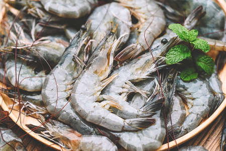 raw shrimp on white plate with mint leaf and shrimps background for cooking, close up fresh shrimps or prawns, seafood shelfishの写真素材