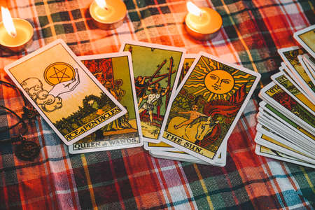 Tarot reading with tarot card background and candlelight on the table for Astrology Occult Magic Spiritual Horoscopes and Palm reading fortune teller tarot readerのeditorial素材