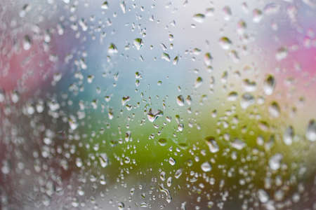 raindrops on glass window in the rainy season, water drop glass background , nature water drop after...