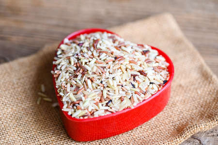 heart rice , brown rice on the sack , various color mixed thai rice for cooking food , Loonzain rice brown black red white purple health food background.の写真素材