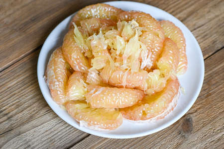 Pomelo fruit on white plate, fresh pomelo peeled frome pomelo tree , pummelo , grapefruit in summer tropical fruit in thailandの写真素材