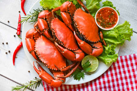 seafood plate with herbs spices rosemary lemon lime salad lettuce vegetable, fresh crab on white plate and seafood sauce, crab cooking food boiled or steamed crab red in the restaurant - top viewの写真素材