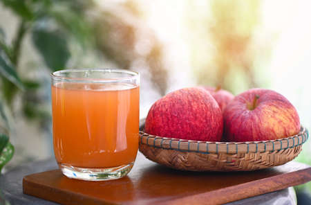 apple cider vinegar natural remedies and cures for common health condition, raw and unfiltered organic apple cider vinegar in glass with apple fruit on the wooden tableの写真素材