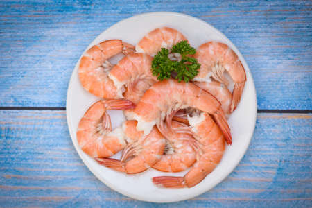 Fresh shrimps served on white plate, boiled peeled shrimp prawns cooked in the seafood restaurant - top viewの写真素材