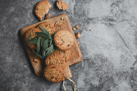 delicious sweet dessert cookie with hemp leaf plant THC CBD herbs food snack and medical, Cannabis food cookies with cake chocolate cannabis leaf marijuana herb on wooden backgroundの写真素材