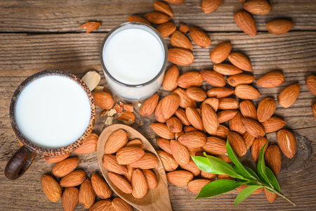Almond milk and Almonds nuts wooden background, Delicious sweet almonds on table, roasted almond nut for healthy food and snack - top viewの写真素材