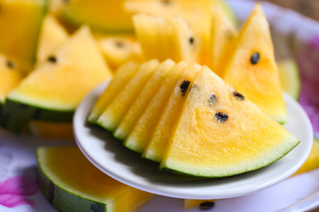 Sweet watermelon slices pieces fresh watermelon tropical summer fruit, Yellow watermelon slice on plateの写真素材