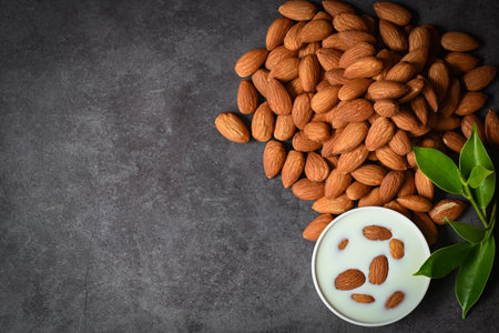 Almond milk and Almonds nuts on dark background, Delicious sweet almonds on table, roasted almond nut for healthy food and snack - top viewの写真素材