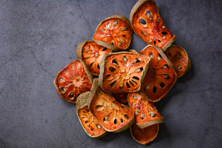 Dried bael slices on dark background, Bael for bael juice - Dry bael fruit tea for health - Aegle marmelosの写真素材