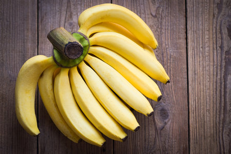 bunch of bananas - banana on wooden background, ripe banana fruit on floor - top viewの写真素材