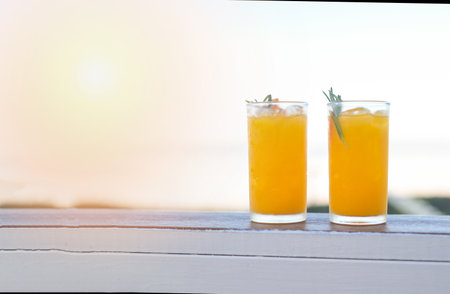 glass of orange juice on wooden table, fresh orange Juice with orange fruit and rosemary in the morning view nature backgroundの写真素材