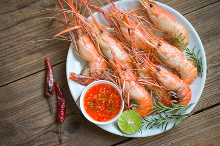 shrimp grilled delicious seasoning spices on white plate background appetizing cooked shrimps baked prawns rosemary lemon lime pepper, Seafood shelfish with seafood sauce - top viewの写真素材