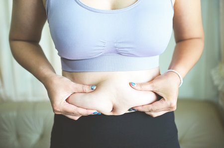 Fat woman measuring , fat woman fat belly chubby paunchy sport recreation health care lose belly fat concept, woman holding excessive bellyの写真素材