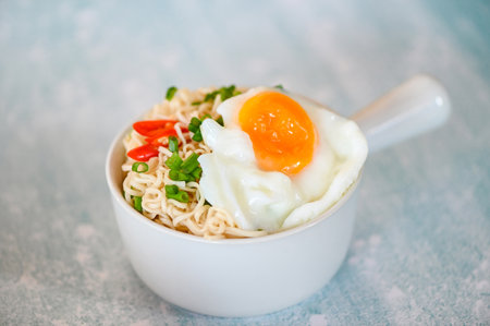 instant noodles cooking tasty eating with bowl, noodles bowl with boiled egg vegetable spring onion and chili on table food, noodle soupの写真素材
