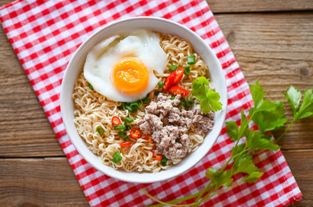 noodles bowl with boiled egg minced pork vegetable spring onion lemon lime lettuce celery and chili on table food , instant noodles cooking tasty eating with bowl noodle soup - top viewの写真素材
