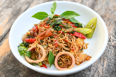 noodles plate with instant noodles stir fried with vegetables herb spicy tasty appetizing asian noodles mix seafood stir fried squid with basil and chilli pepper - top viewの写真素材