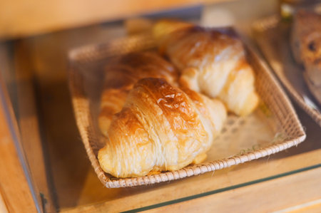 Croissants on wooden basket, croissants for dessert - fresh homemade butter croissants in bakery cake shopの写真素材
