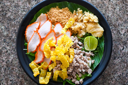 yellow noodles Thai food - dried noodles food on plate with condiment minced pork lemon lime peanuts dumpling red pork on plateの写真素材