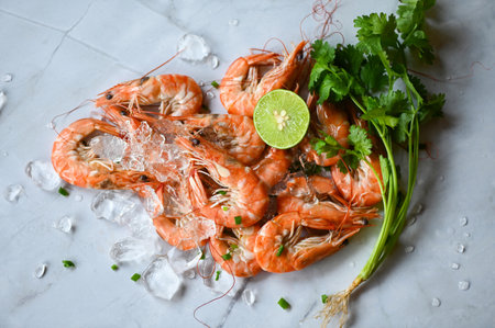 cooking shrimp food on white plate background dining table food, Fresh shrimps prawns seafood lemon lime with herbs and spice, top viewの写真素材