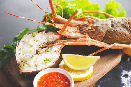 spiny lobster food on plate, fresh lobster or rock lobster seafood with herb and spices lemon coriander parsley lettuce salad, lobster for cooking food and seafood sauceの写真素材