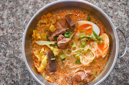 noodles bowl curry bone soup - bone soup pork with boiled eggs in hot pot, Thai food tom yum hot and sour soup - top viewの写真素材