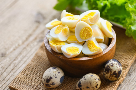 boiled eggs food, quail eggs on wooden bowl, breakfast eggs with fresh quail eggs and vegetable lettuce on table backgroundの写真素材