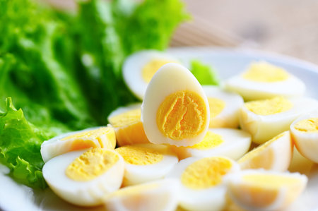 boiled eggs food, quail eggs on white plate, breakfast eggs with fresh quail eggs and vegetable lettuce on table backgroundの写真素材