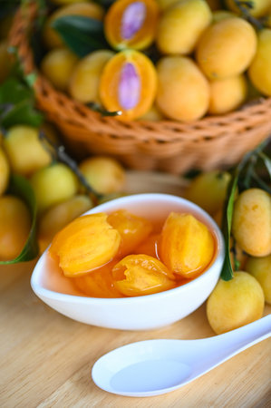 Sweet dessert marian plum fruit  on bowl for food and wooden background, tropical fruit Name in Thailand sweet Yellow Marian Plum Maprang Plango or Mayong chidの写真素材
