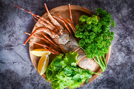 fresh lobster or rock lobster seafood with herb and spices lemon coriander parsley lettuce salad, spiny lobster food on plate, lobster for cooking food and seafood sauceの写真素材
