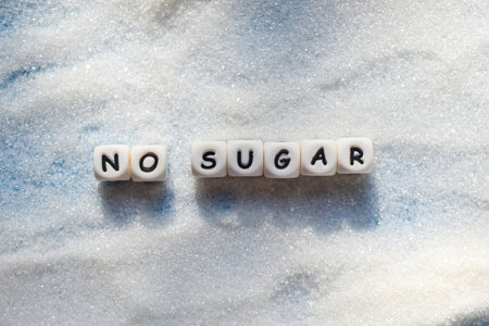 no sugar text blocks with white sugar on wooden background, suggesting dieting and eat less sugar for health conceptの写真素材