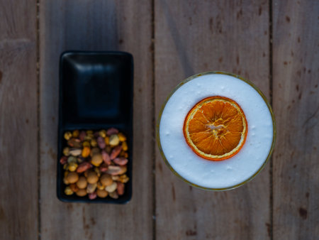 a cocktail with a slice of dried orange and a snackの写真素材