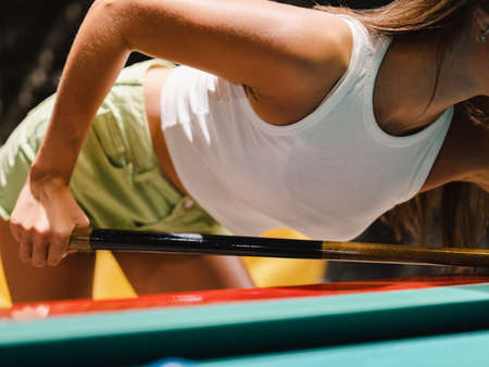 attractive young woman playing billiards