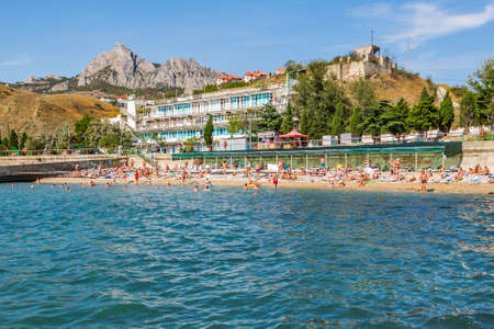 Koktebel, Republic of Crimea - September 9, 2018: Black sea. Beach and hotel against the background of the ancient extinct volcano Kara Dagのeditorial素材