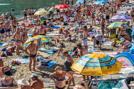 Novy Svet (New World), Sudak, Republic of Crimea - September 11, 2018: Black Sea. A crowded beach in a green bay near the mountain Koba Kaya.のeditorial素材